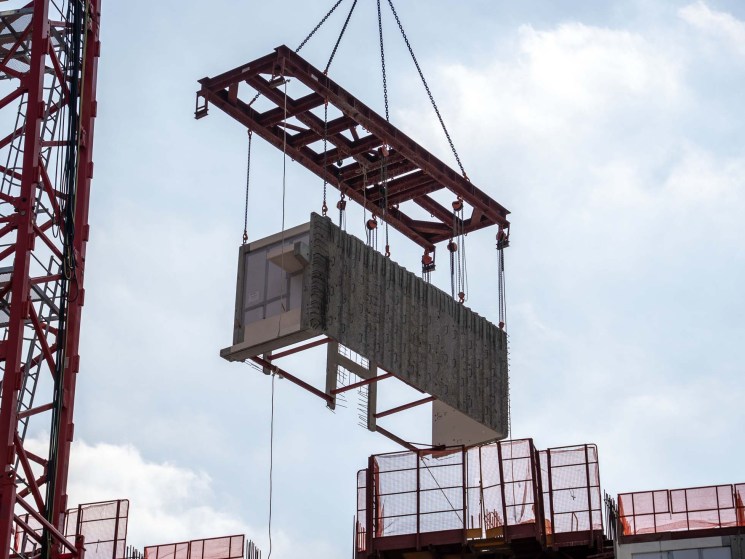A construction crane is lifting a Modular Integrated Construction module at a construction site for a public housing project in Hong Kong, China, on December 4, 2023. Hong Kong Modular Integrated Construction For Public Housing - 05 Dec 2023
